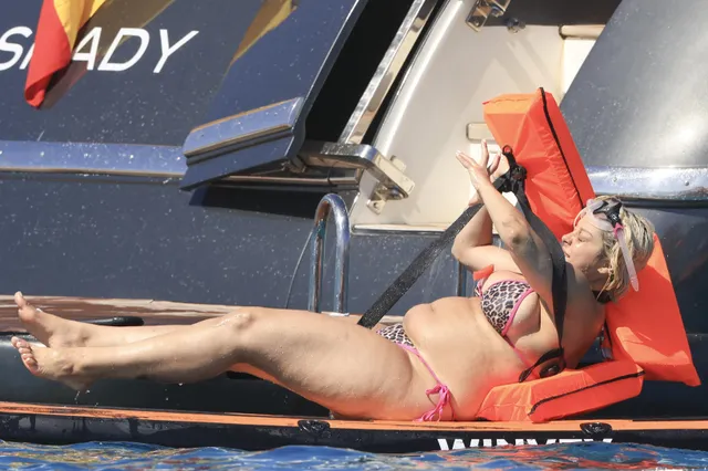 Bebe Rexha reclining barefoot on a paddleboard.