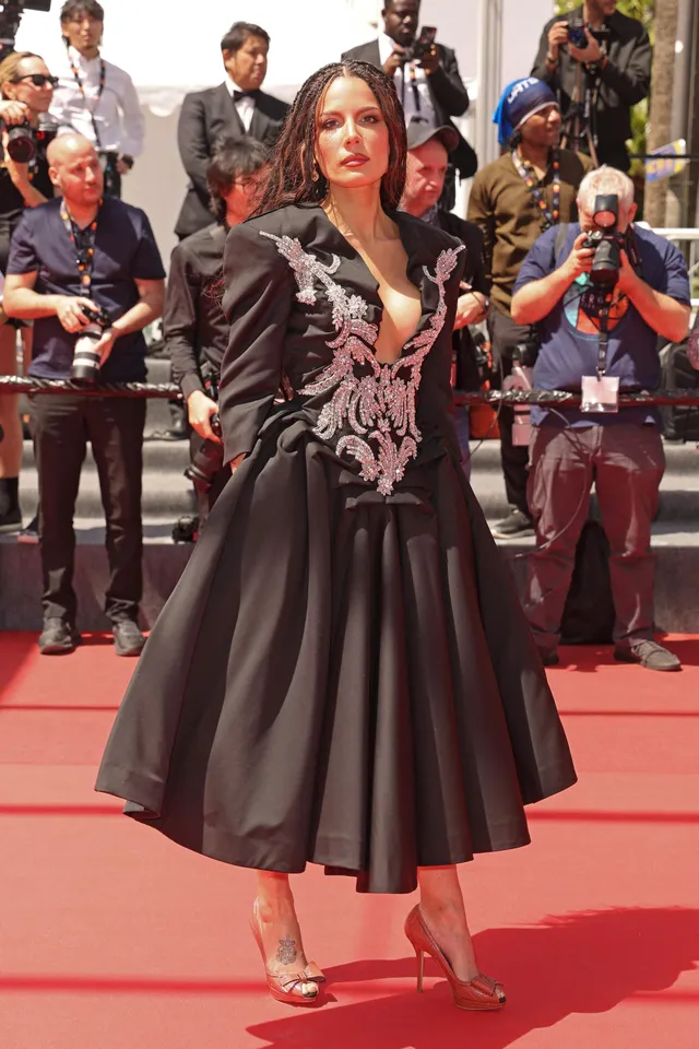 Halsey a black dress and heels on red carpet.