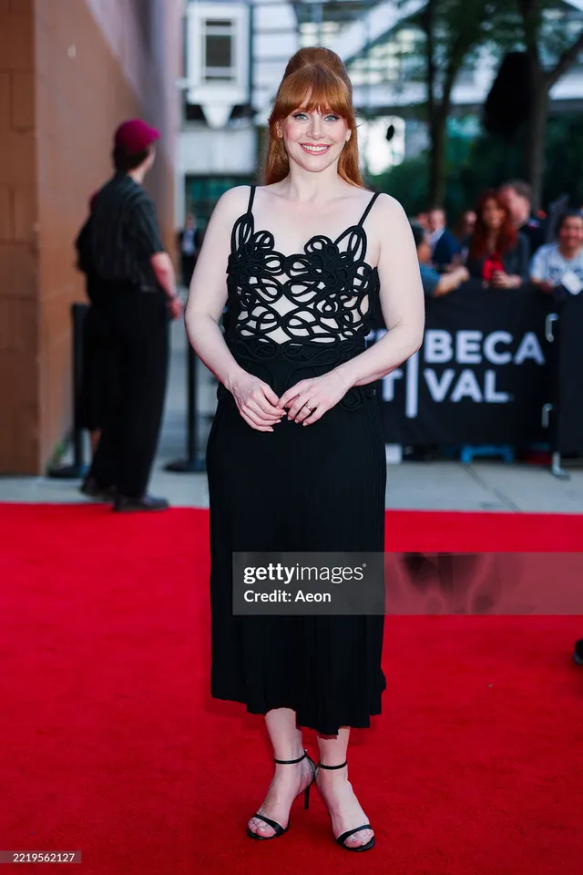 Bryce Dallas Howard standing at a film festival in a black dress.