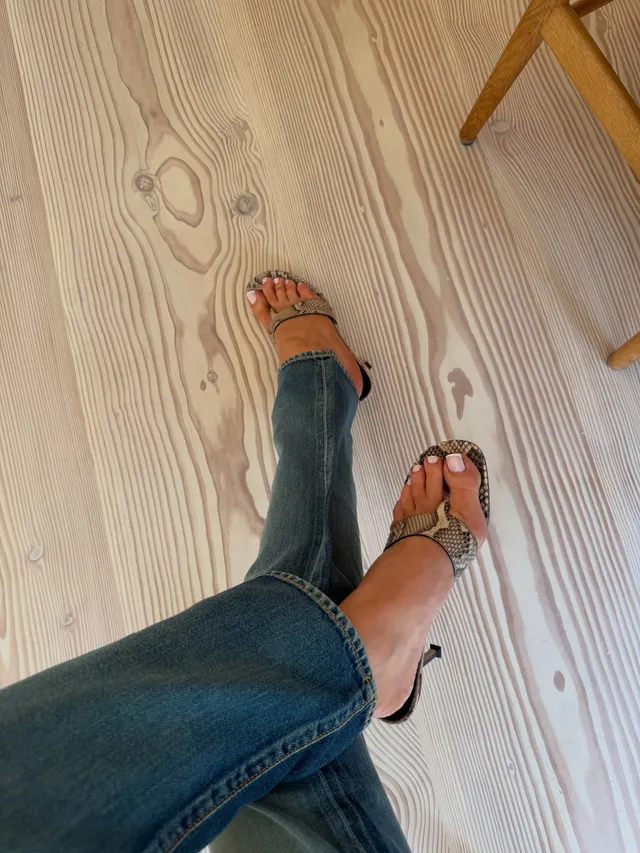 Rosie Huntington-Whiteley a detail of strappy heels beneath jeans.