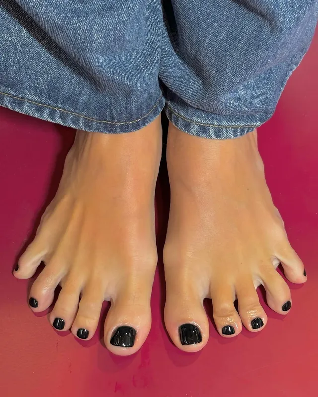 Lily Allen: close view of bare feet beneath blue jeans.