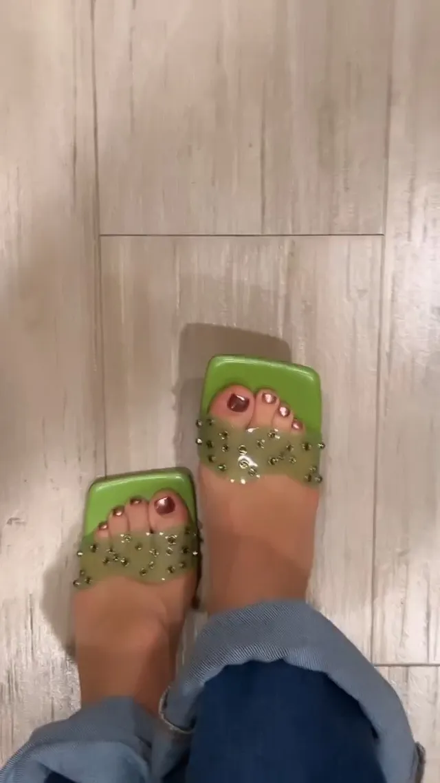 Isabela Merced wearing square-toed green heels with painted toenails.