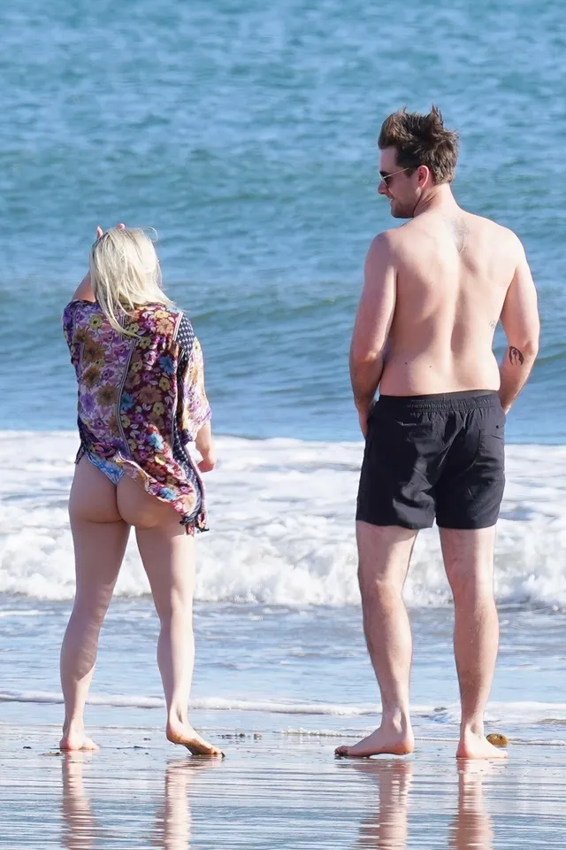 Ariel Winter standing with a companion beside the sea.
