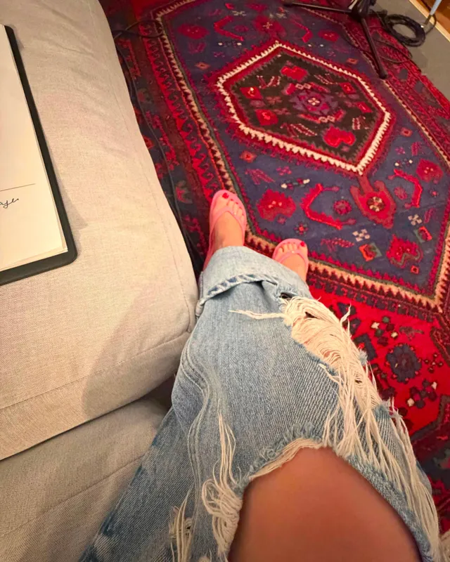 Kylie Minogue a bare foot below torn jeans.