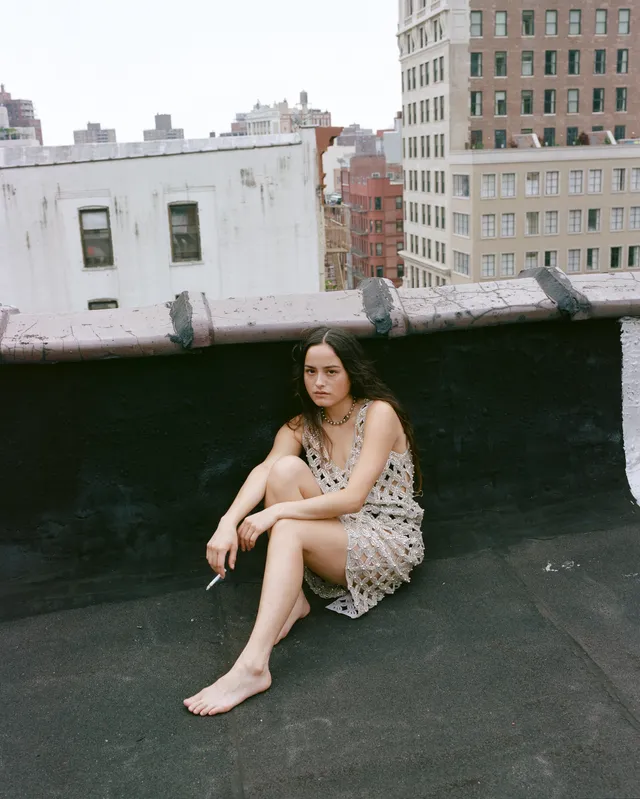 Chase Sui Wonders sitting barefoot on a rooftop.