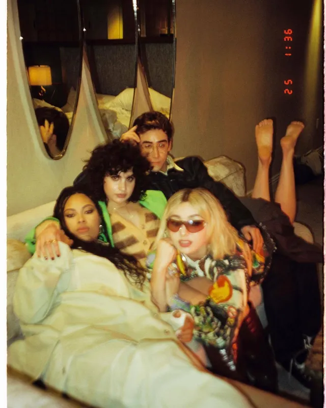 Peyton List posing with friends in colorful indoor outfits.