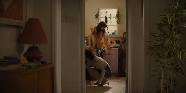 Odessa A'zion standing indoors in heels in a scene.
