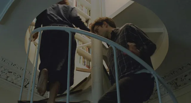 Zendaya: bare feet raised beside a bed frame in a film scene.