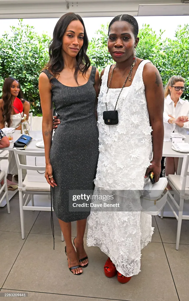Zoe Saldaña posing with a guest at a beauty event.