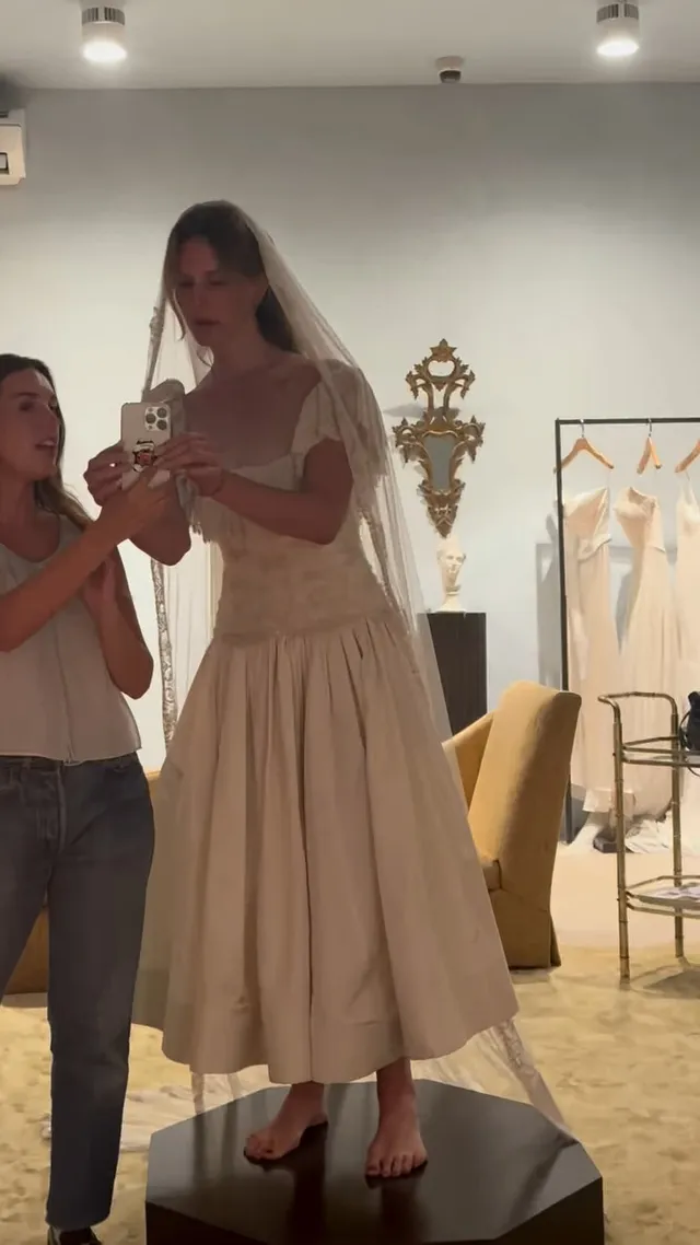 Lana Del Rey standing barefoot in a pale dress during a fitting.
