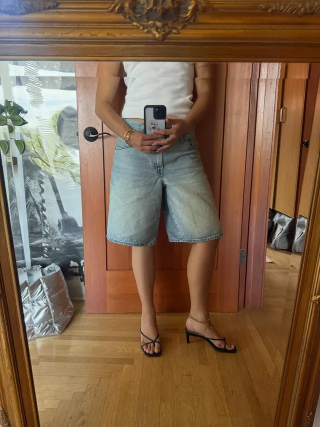 Mackenzie Ziegler taking a mirror selfie in shorts and flip-flops.
