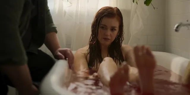 Isla Fisher resting her feet in a bath during a screen scene.