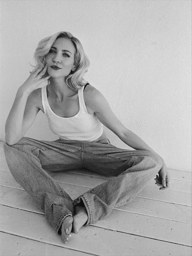Brittany Snow sitting cross-legged for a black-and-white portrait.
