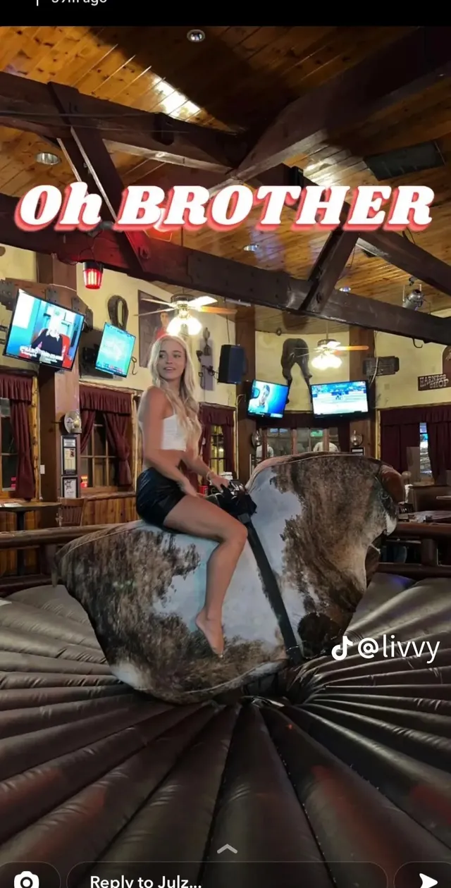 Olivia Dunne sitting on a saddle display inside a shop.