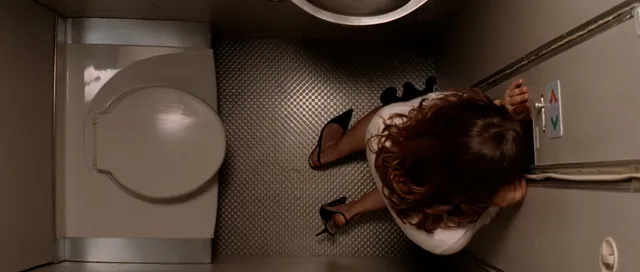 Rachel McAdams standing in heels in a washroom in an overhead film scene.