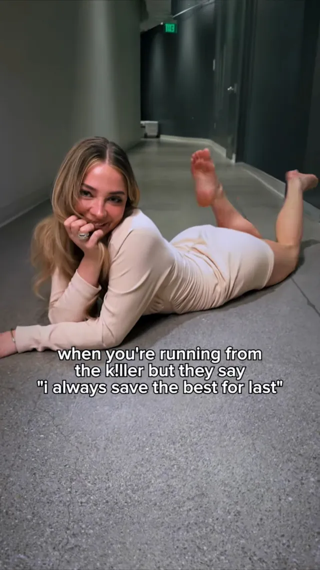 Madelyn Cline lying on a corridor carpet with one bare sole facing the camera.