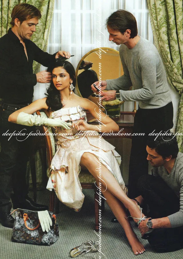 Deepika Padukone sitting barefoot in a chair while stylists prepare her outfit.