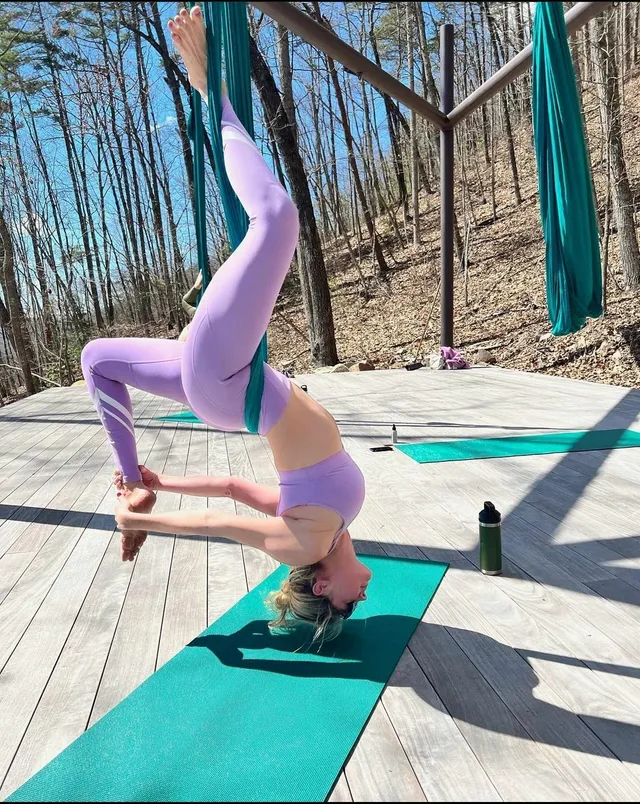 Kate Upton holding a barefoot yoga pose on an outdoor mat.