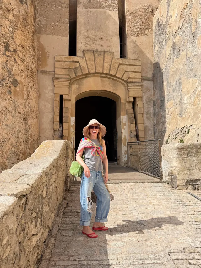 Kylie Minogue a casual denim outfit and red sandals outdoors.