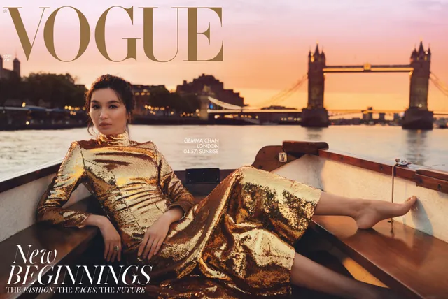 Gemma Chan reclining on a boat with Tower Bridge behind her.