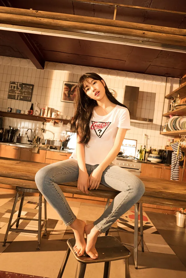 Bae Suzy sitting barefoot on a kitchen stool.