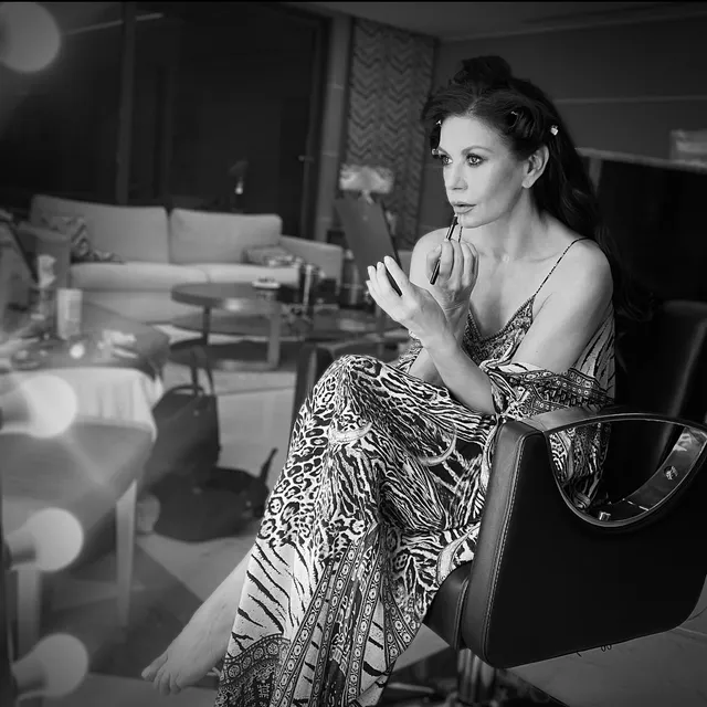 Catherine Zeta-Jones a monochrome seated portrait in a patterned dress.