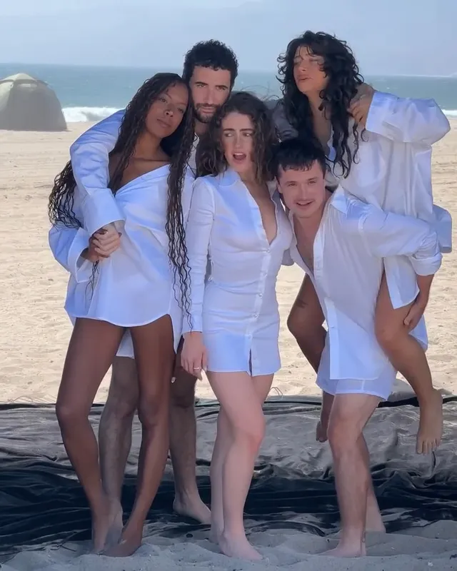 Odessa A'zion posing barefoot on a beach with cast members.