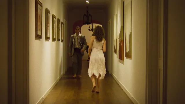 Odessa A'zion wearing a pale dress while walking barefoot in a scene.