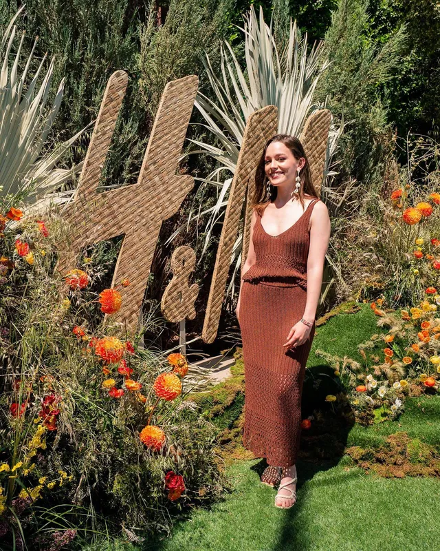 Victoria Pedretti posing at an outdoor event in a brown outfit.