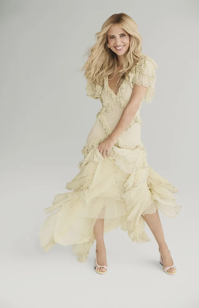 Sarah Michelle Gellar posing in a pale layered dress and white heels.