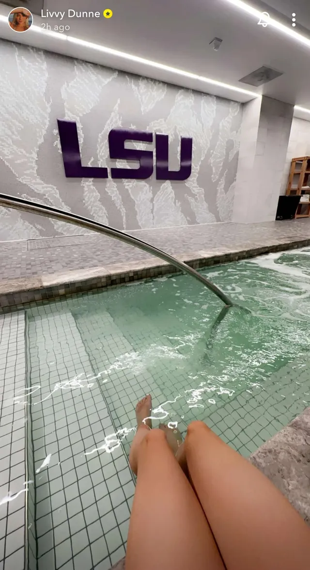 Olivia Dunne resting with her feet visible in a pool.