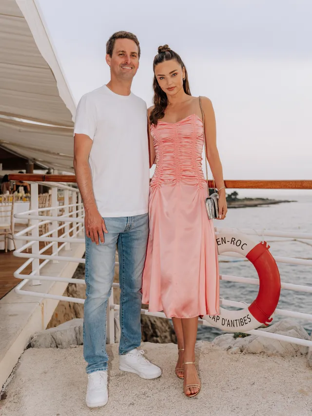 Miranda Kerr a pink dress and gold heels on a boat.