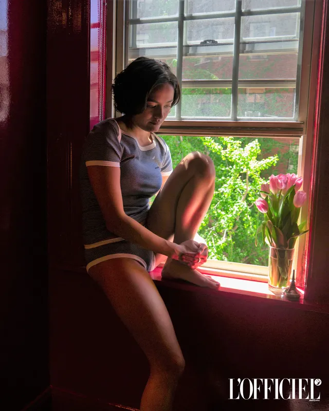 Chase Sui Wonders sitting barefoot beside a window.