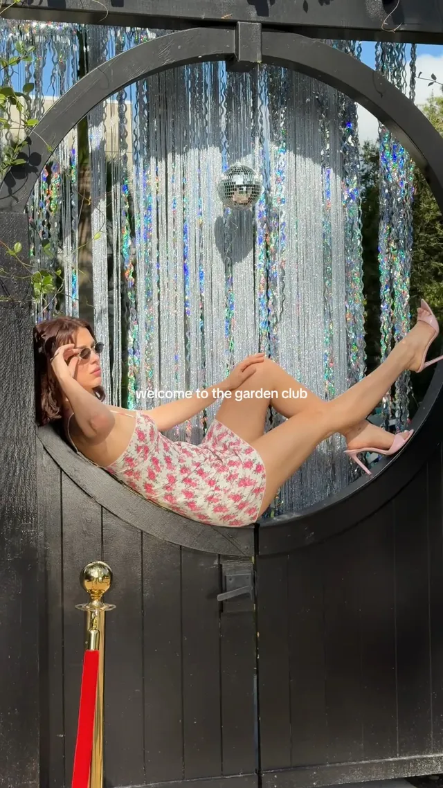 Millie Bobby Brown reclining on a hanging garden seat.