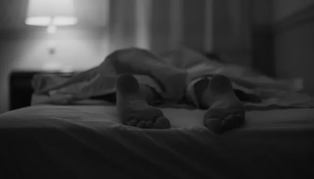 Alicia Vikander lying on a bed in a monochrome screen scene.