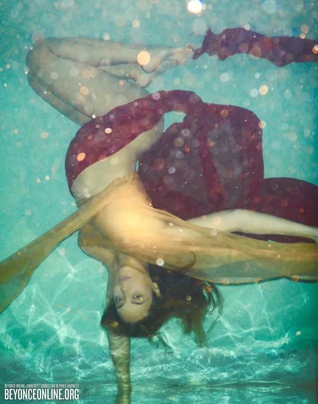 Beyoncé floating underwater with bare feet visible.
