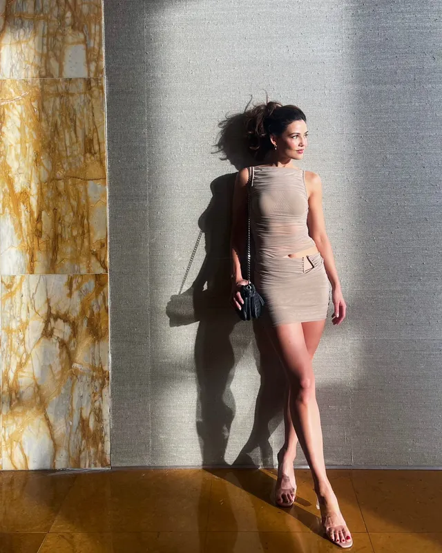 Danielle Campbell posing in sunlight against a wall.