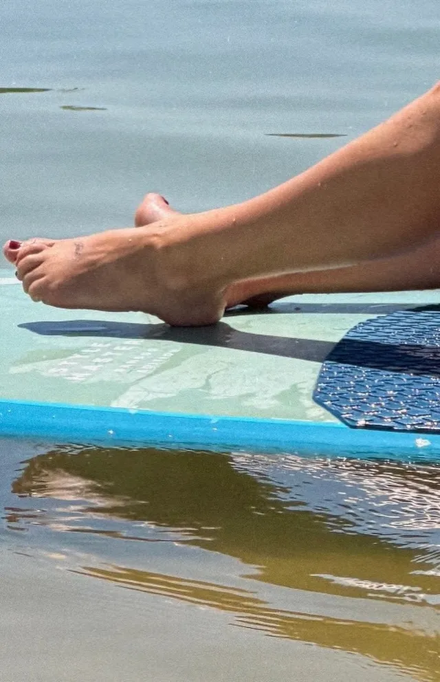 Millie Bobby Brown resting her feet over the edge of a boat.