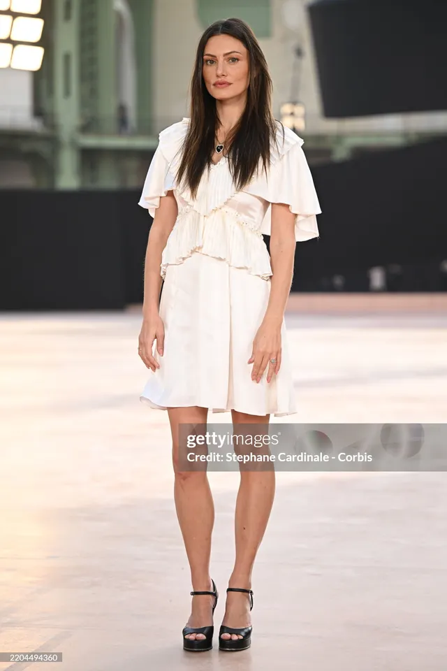 Phoebe Tonkin posing at an event in a white dress.