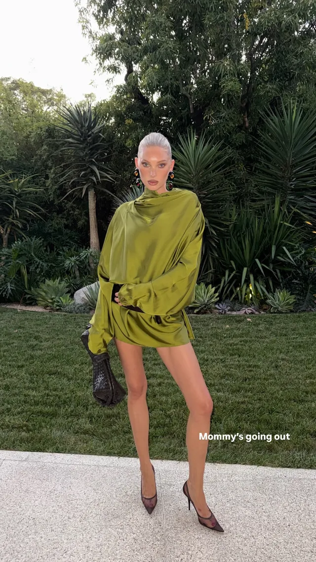 Elsa Hosk standing on a garden path in a green outfit and patterned heels.