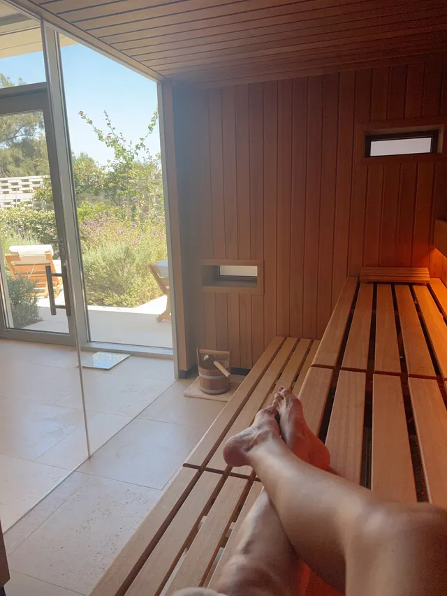 Kate Hudson relaxing on a wooden bench in a sauna.