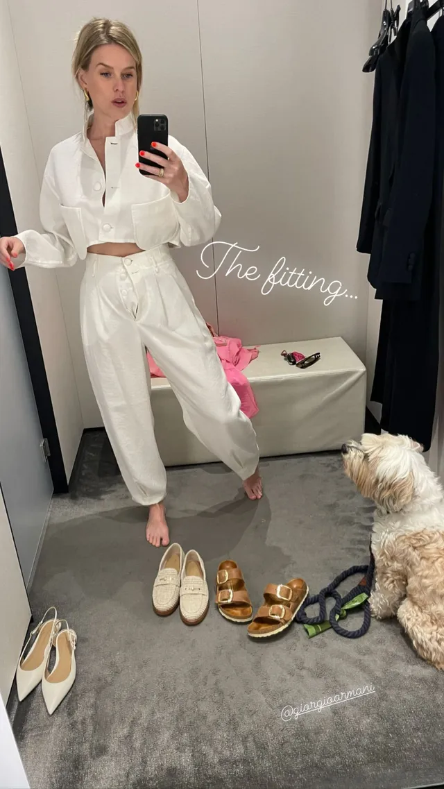 Alice Eve taking a mirror photograph in a white outfit.