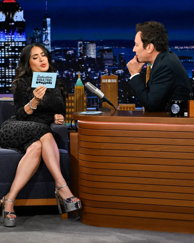 Salma Hayek wearing patterned platform sandals on a talk show.