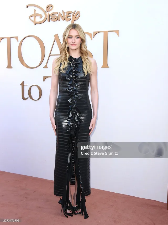 Sarah Pidgeon posing in a long black dress and bow-detail heels.