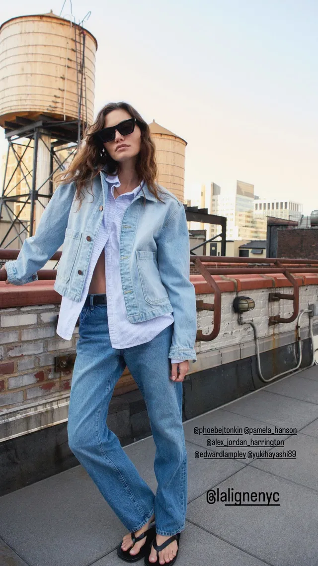 Phoebe Tonkin posing on a rooftop in jeans and flip-flops.