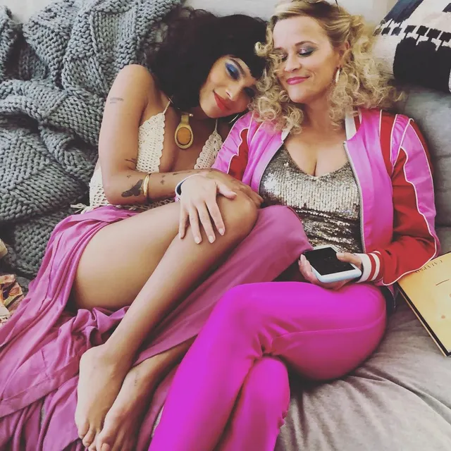 Zoë Kravitz sitting beside a companion in a screen scene.