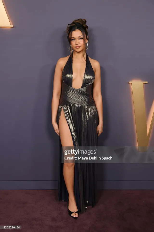 Madison Bailey wearing a long black gown and open-toe heels at an event.