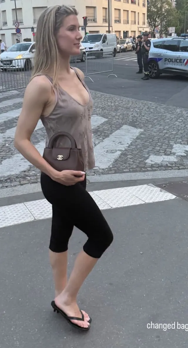 Eugenie Bouchard walking in flat sandals with cropped exercise trousers.