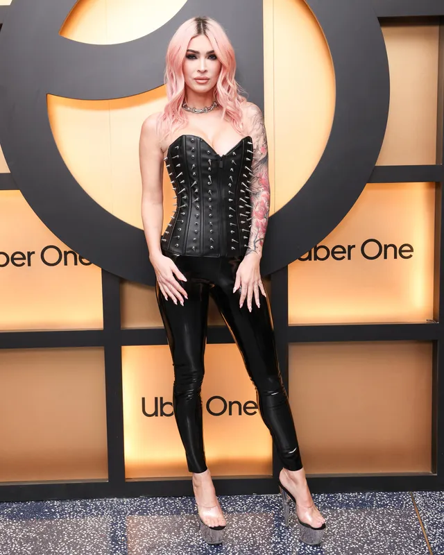 Megan Fox posing in black trousers and pale high heels.
