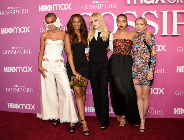 Whitney Peak posing with fellow performers in an embellished top, dark skirt and gold heels.